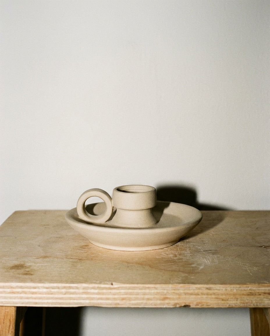 Tsuchi chamberstick styled beside a beige vase