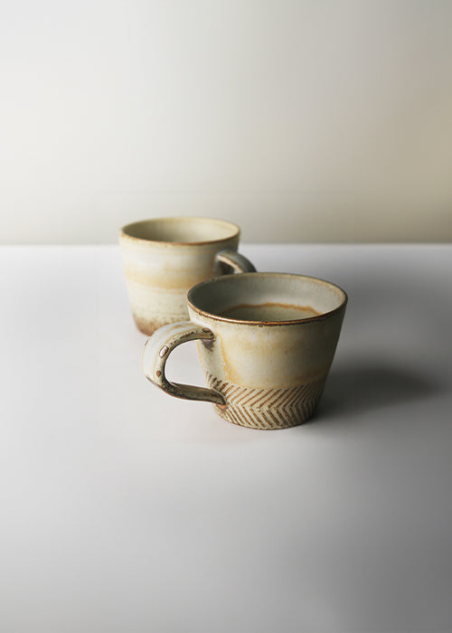 Firelight-inspired mugs, featuring a distinctive, slightly burnt appearance that evokes the cozy ambiance of a crackling fire. Meticulously crafted with precision and care, these mugs harmonize rustic charm with a modern design sensibility. Each sip from these mugs offers a comforting embrace, reminiscent of enjoying your favorite brew by a fireside.