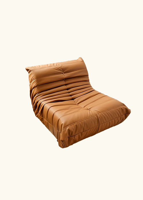 A trendy and comfy Caterpillar/Togo Chair in Toffee color with solid wood base, vegan leather upholstery, and sponge filling. Featuring a special concave ergonomic design for support and good posture. Removable and washable cover. Dimensions: W76cm x H70cm x D100cm