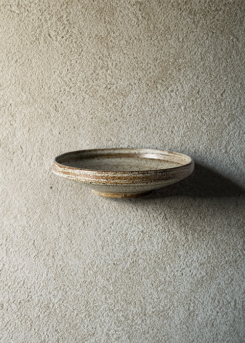 Handmade stone wide bowl, measuring W21.3cm x H5cm. Featuring a rugged yet sleek style, this bowl is part of a comprehensive set of raw pottery dishes and mugs designed for versatile dining needs.