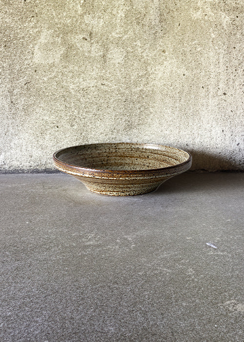 Handmade stone small bowl, measuring W18.3cm x H4.5cm. Exhibiting a rugged yet sleek style, this bowl is part of a comprehensive set of raw pottery dishes and mugs designed for versatile dining needs.
