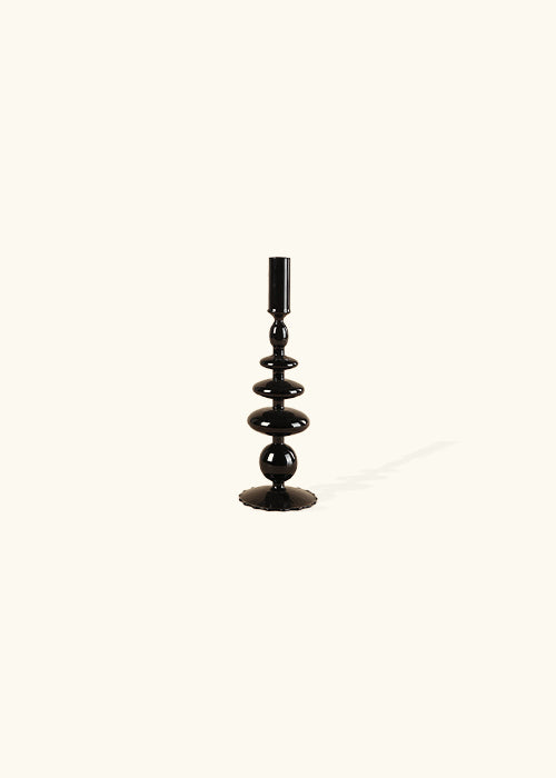 Introducing our Midnight Glass Candlesticks: A perfect fusion of classic charm and modern style. With a uniquely retro-inspired design and a sleek glass construction, these candlesticks effortlessly add sophistication to any space. Elevate your ambiance with this exquisite blend of vintage allure and contemporary elegance. Additional features include black glass candlesticks, available in 3 styles, modern retro style, and unique shapes.