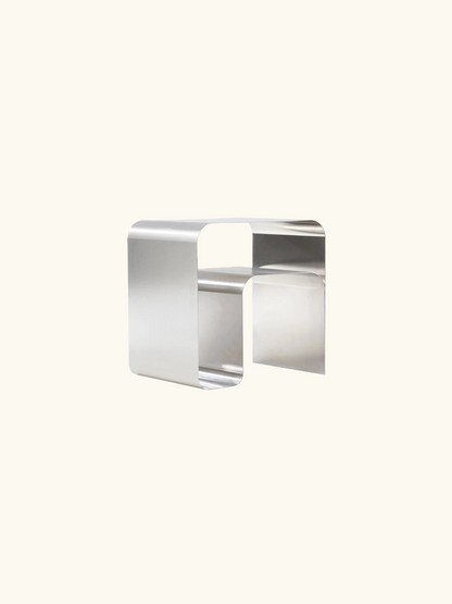 A modern Stainless Steel Side Table with sleek stainless steel construction, combining industrial style and functionality. Features a top surface for displaying items and practical horizontal and vertical storage space inside. Dimensions: W45 x H45 x D35